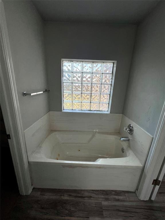full bath with a jetted tub and wood finished floors