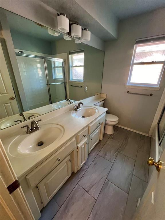 bathroom featuring a shower stall, a sink, and toilet