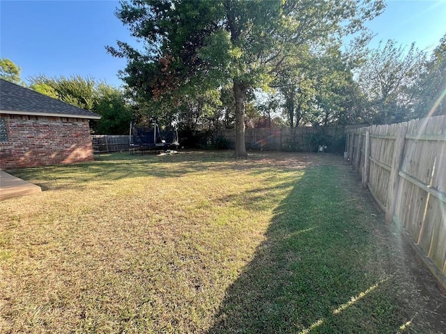 view of yard with a fenced backyard and a trampoline