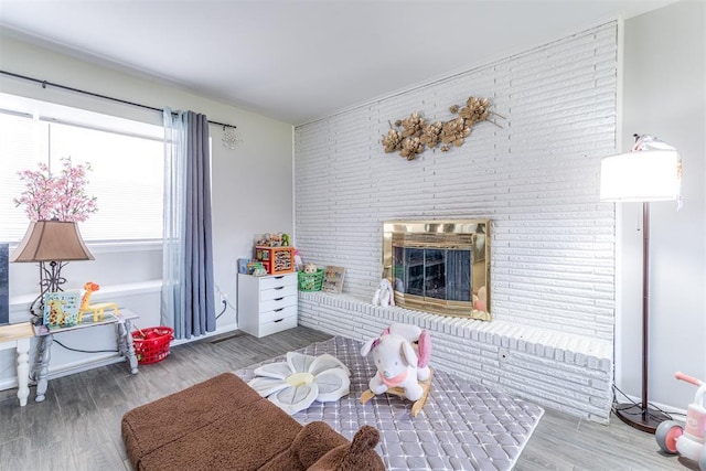 2428 SW 79th St, Oklahoma City, OK 73159 - living room featuring brick wall, wood finished floors, and a fireplace
