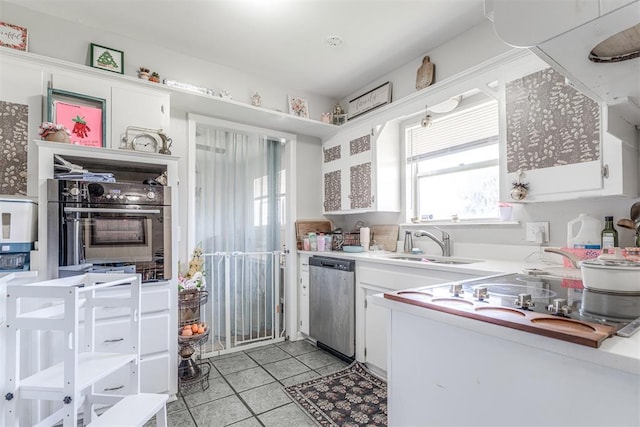 2428 SW 79th St, Oklahoma City, OK 73159 - kitchen with light tile patterned floors, stainless steel dishwasher, white cabinets, and light countertops