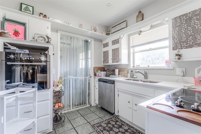 2428 SW 79th St, Oklahoma City, OK 73159 - kitchen with a sink, light tile patterned floors, white cabinetry, light countertops, and appliances with stainless steel finishes