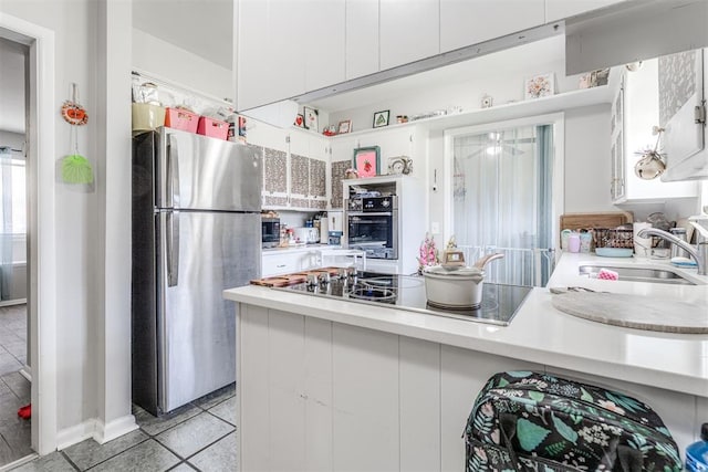 2428 SW 79th St, Oklahoma City, OK 73159 - kitchen featuring white cabinets, light countertops, appliances with stainless steel finishes, and light tile patterned flooring