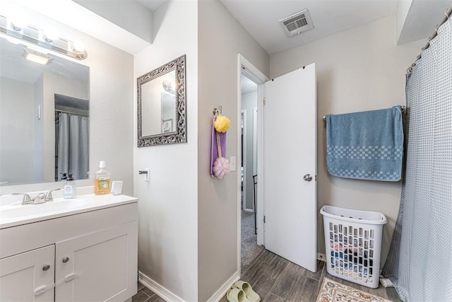 2428 SW 79th St, Oklahoma City, OK 73159 - full bathroom with baseboards, wood finished floors, visible vents, and vanity