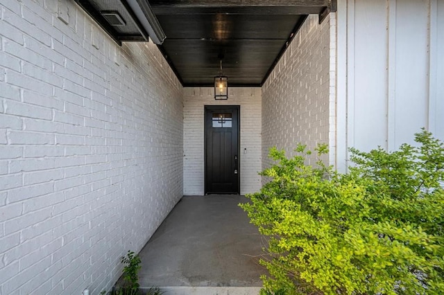 entrance to property featuring brick siding