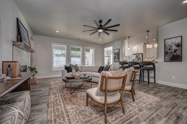 living area with baseboards, recessed lighting, ceiling fan, and dark wood-style floors