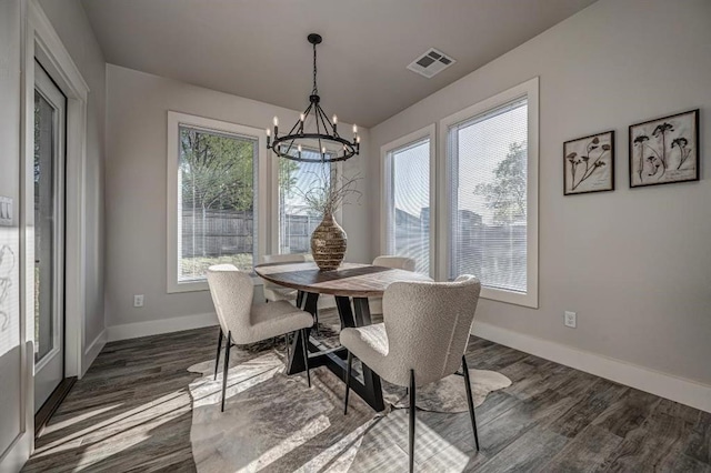 dining space with baseboards, a chandelier, and dark wood finished floors