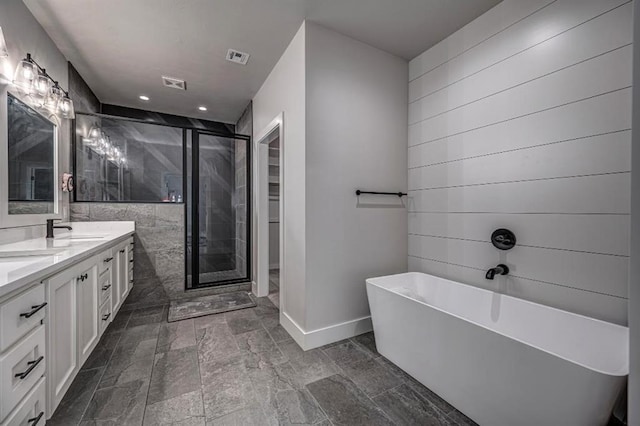full bathroom with a shower stall, a freestanding tub, visible vents, a sink, and baseboards