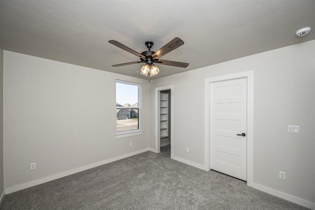 unfurnished bedroom featuring ceiling fan, baseboards, and carpet floors