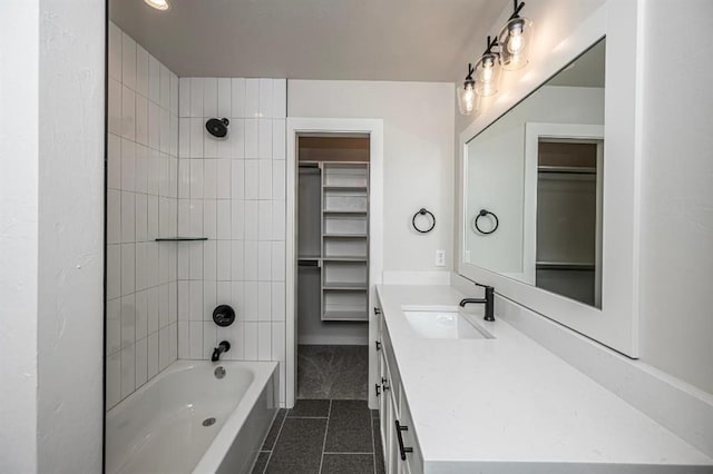 bathroom with a spacious closet, tile patterned floors, vanity, and tub / shower combination
