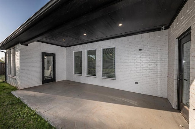 exterior space featuring a patio area and brick siding