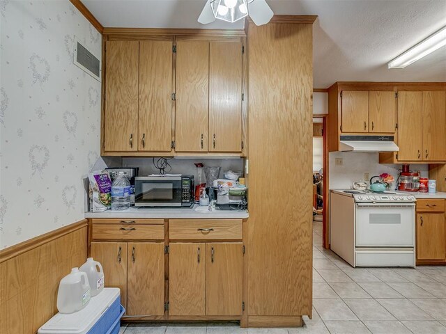 209 S 2nd Ave, Stroud, OK 74079 - kitchen with wallpapered walls, light countertops, white range oven, and under cabinet range hood