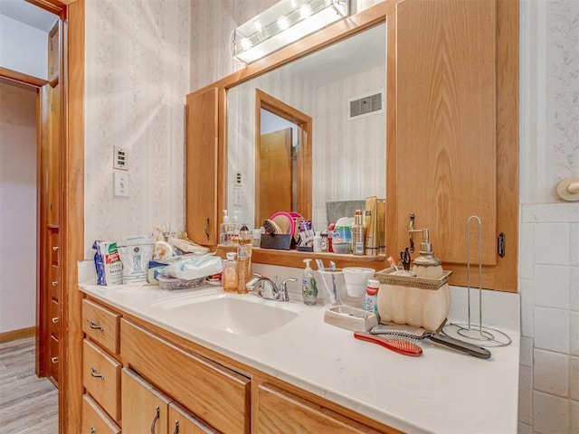 209 S 2nd Ave, Stroud, OK 74079 - bathroom featuring wallpapered walls, vanity, and visible vents