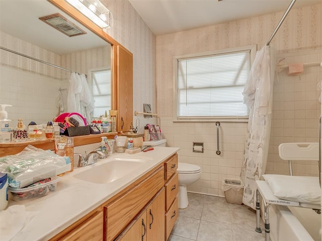 209 S 2nd Ave, Stroud, OK 74079 - bathroom with vanity, wallpapered walls, tile patterned flooring, toilet, and tile walls