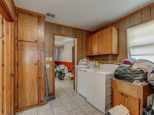 209 S 2nd Ave, Stroud, OK 74079 - clothes washing area with cabinet space, wood walls, washing machine and dryer, and visible vents