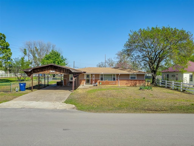 209 S 2nd Ave, Stroud, OK 74079 - ranch-style house with a carport, fence, a front lawn, brick siding, and driveway