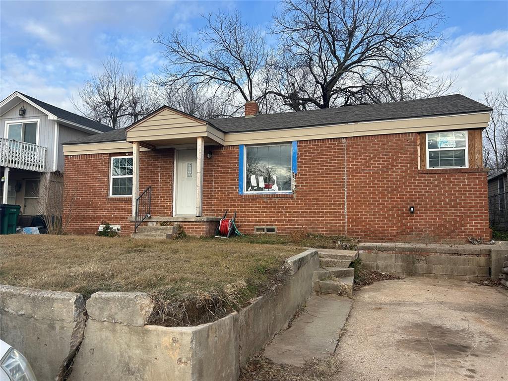 1157 E Bellevidere Dr, Oklahoma City, OK 73117 - view of front of property with roof with shingles, brick siding, and a chimney