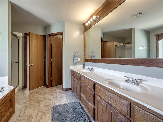 full bathroom featuring visible vents, a sink, double vanity, and a shower stall