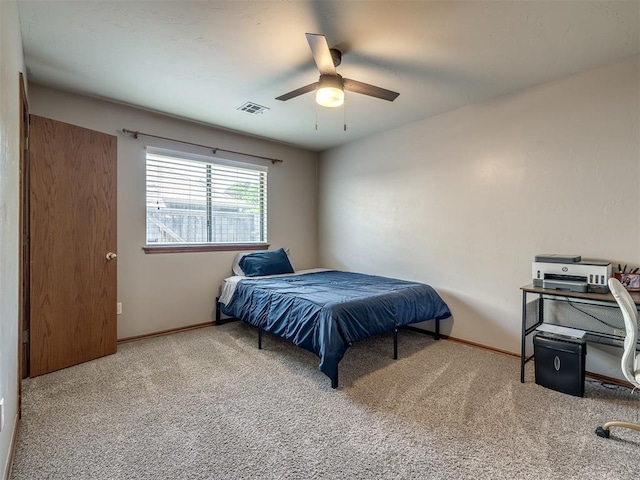 carpeted bedroom with baseboards, a ceiling fan, and visible vents