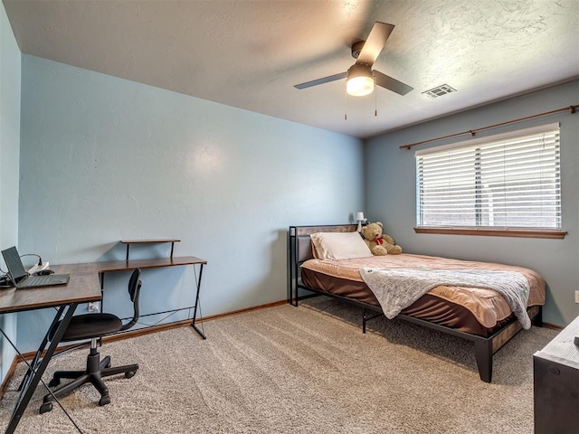 bedroom with carpet floors, a textured ceiling, baseboards, and visible vents