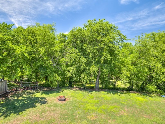 view of yard featuring fence and an outdoor fire pit