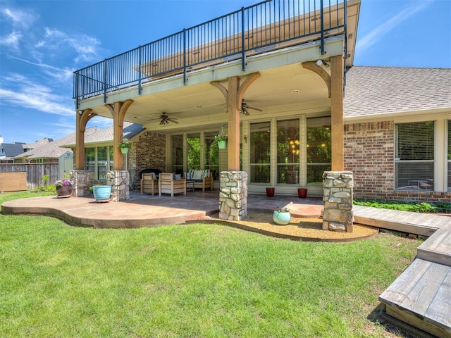 back of property with brick siding, ceiling fan, a balcony, and a patio area