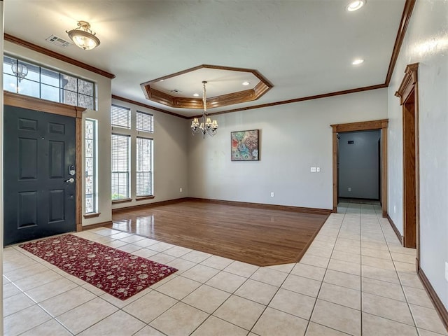 entrance foyer with crown molding, a raised ceiling, a notable chandelier, and light tile patterned flooring