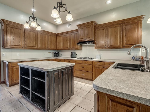 kitchen with stainless steel gas cooktop, open shelves, a sink, light tile patterned floors, and under cabinet range hood