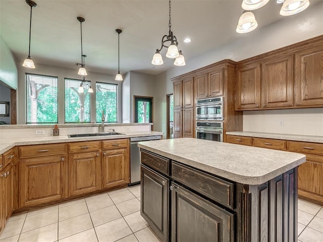 kitchen with a kitchen island, appliances with stainless steel finishes, a sink, light countertops, and light tile patterned flooring