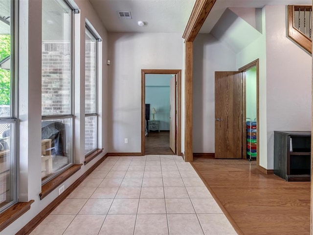 interior space featuring light tile patterned floors, baseboards, and visible vents