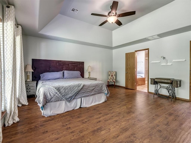 bedroom with baseboards, ensuite bathroom, wood finished floors, and visible vents