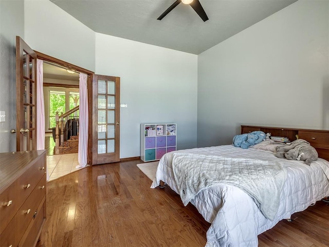 bedroom featuring baseboards, a ceiling fan, french doors, and wood finished floors