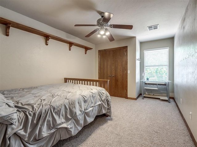 bedroom featuring ceiling fan, visible vents, baseboards, a closet, and light carpet