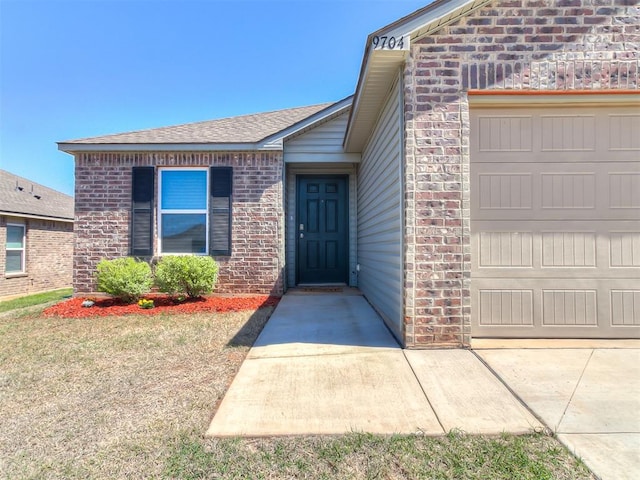 9704 Saddle Dr, Yukon, OK 73099 - doorway to property with a garage and brick siding