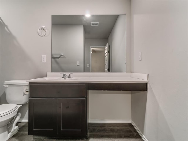 9704 Saddle Dr, Yukon, OK 73099 - half bathroom with vanity, visible vents, toilet, and wood finished floors