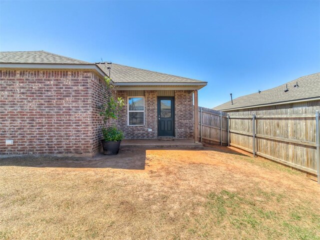 9704 Saddle Dr, Yukon, OK 73099 - rear view of property with brick siding, fence, and a shingled roof