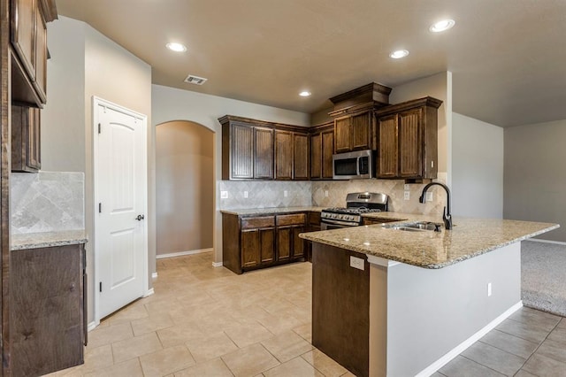 5800 SE 142nd St, Oklahoma City, OK 73165 - kitchen with a sink, appliances with stainless steel finishes, light stone counters, and a peninsula