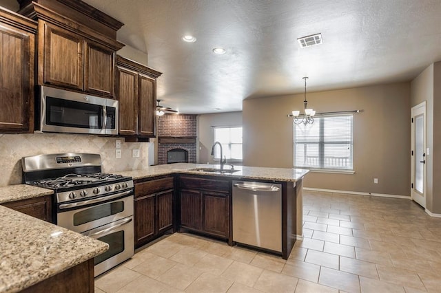 5800 SE 142nd St, Oklahoma City, OK 73165 - kitchen with a peninsula, visible vents, appliances with stainless steel finishes, ceiling fan with notable chandelier, and a sink