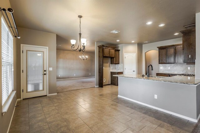 5800 SE 142nd St, Oklahoma City, OK 73165 - kitchen featuring arched walkways, a notable chandelier, a sink, recessed lighting, and decorative backsplash