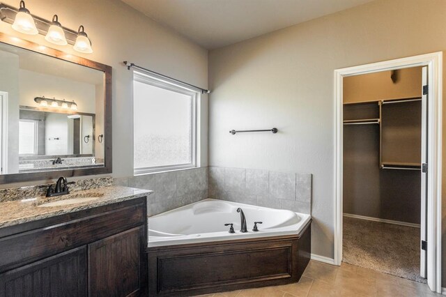 5800 SE 142nd St, Oklahoma City, OK 73165 - full bath featuring a spacious closet, tile patterned flooring, vanity, and a garden tub
