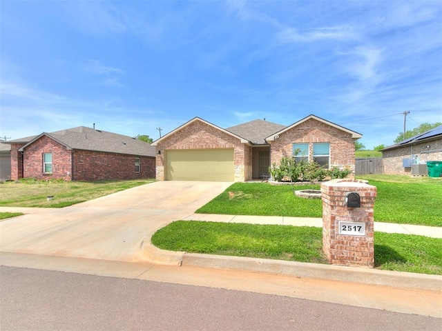 single story home featuring brick siding, an attached garage, a front yard, and concrete driveway