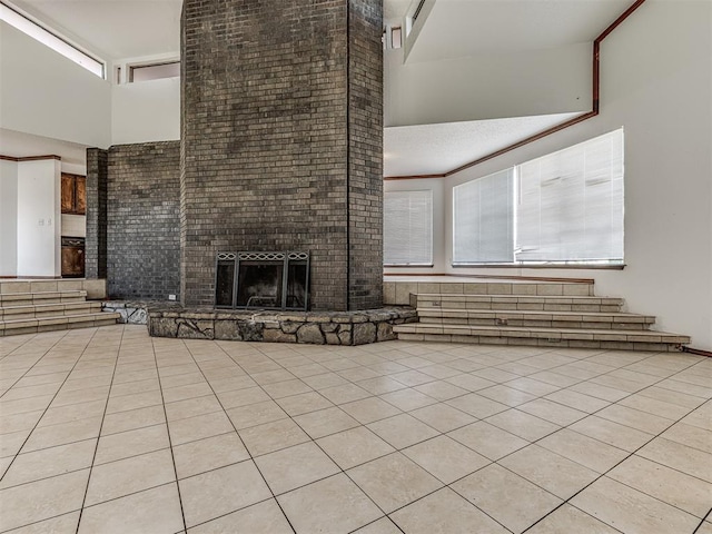 7700 S Country Club Dr, Oklahoma City, OK 73159 - unfurnished living room with plenty of natural light, a brick fireplace, a high ceiling, and light tile patterned flooring