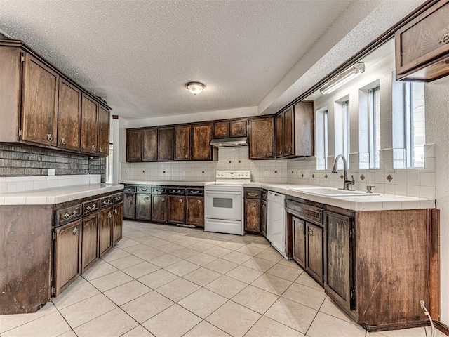 7700 S Country Club Dr, Oklahoma City, OK 73159 - kitchen with dark brown cabinets, decorative backsplash, a sink, and white appliances