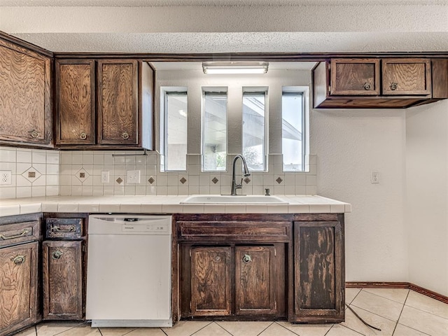 7700 S Country Club Dr, Oklahoma City, OK 73159 - kitchen with dark brown cabinets, dishwasher, tasteful backsplash, and a sink