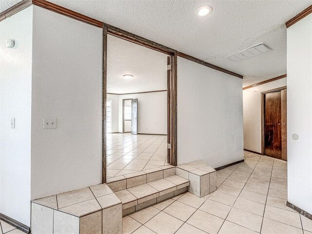 7700 S Country Club Dr, Oklahoma City, OK 73159 - hall with crown molding, a textured ceiling, visible vents, and light tile patterned floors