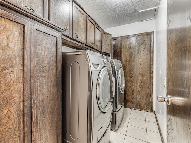 7700 S Country Club Dr, Oklahoma City, OK 73159 - laundry area featuring light tile patterned floors, washing machine and clothes dryer, cabinet space, a textured ceiling, and attic access