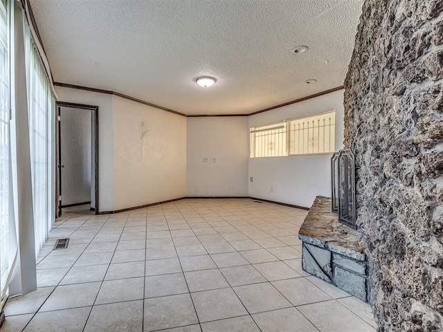 7700 S Country Club Dr, Oklahoma City, OK 73159 - unfurnished room featuring a textured ceiling, light tile patterned floors, ornamental molding, and visible vents