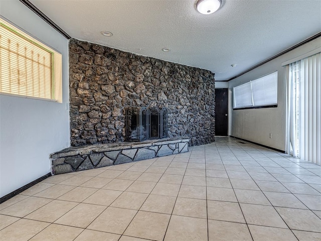 7700 S Country Club Dr, Oklahoma City, OK 73159 - unfurnished living room with light tile patterned flooring, a stone fireplace, and a textured ceiling