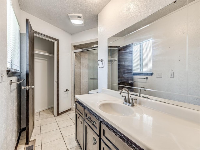 7700 S Country Club Dr, Oklahoma City, OK 73159 - bathroom featuring a shower stall, tile patterned floors, a textured ceiling, vanity, and visible vents