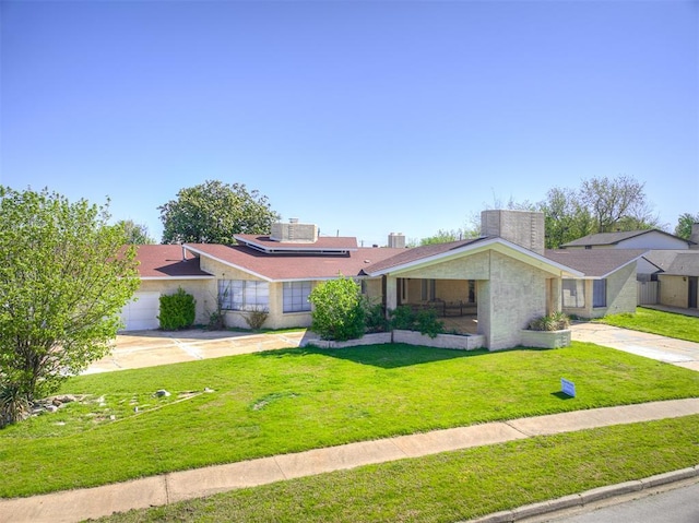 7700 S Country Club Dr, Oklahoma City, OK 73159 - view of front facade featuring roof mounted solar panels, driveway, a front yard, and a garage